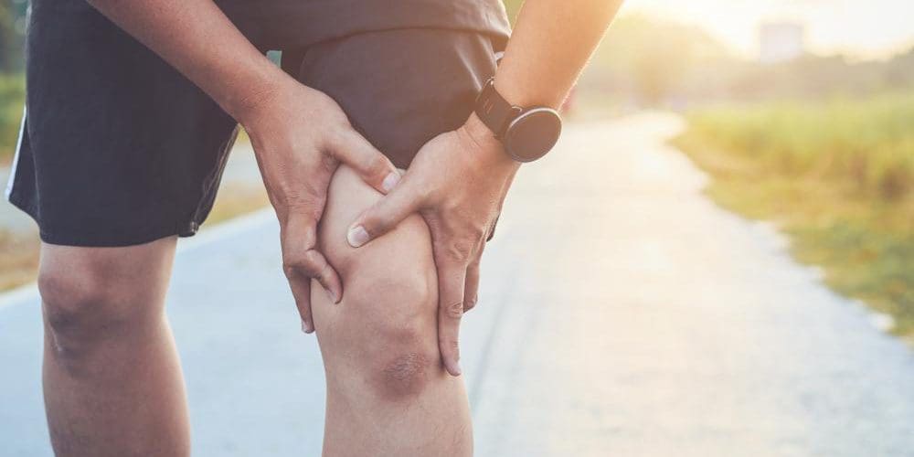 Runner holding onto a sore knee.