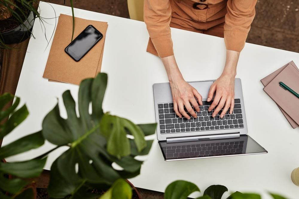 Overhead view of a woman working at a desk on her laptop.