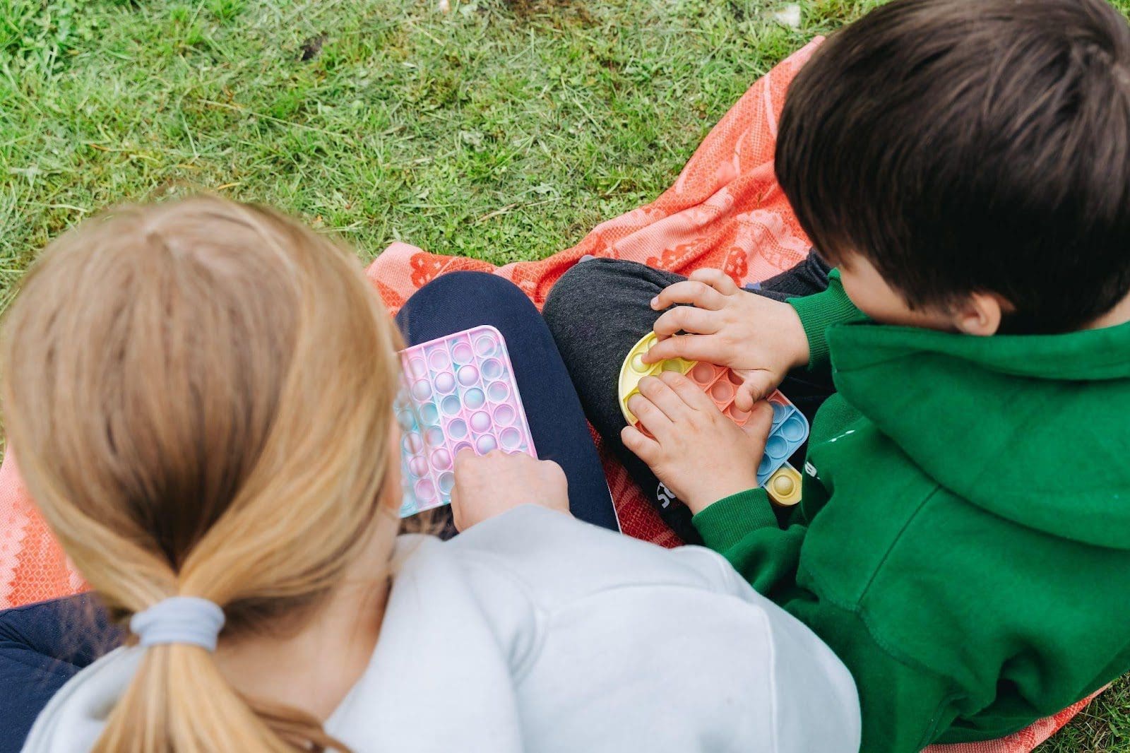 Two young children playing with Poppit toys.