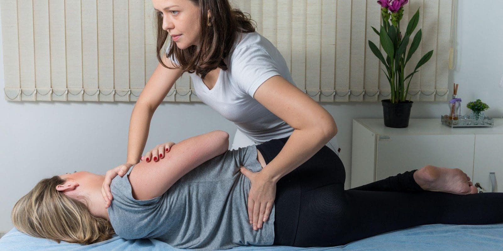 Chiropractor working on a young woman's lower back from annular tear.