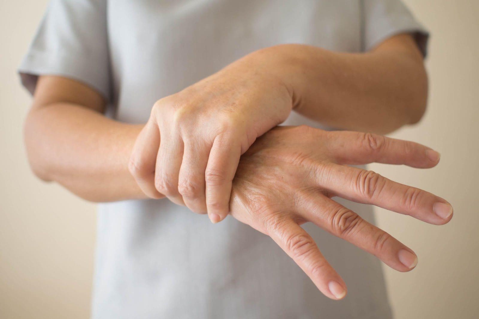 Close-up of a man holding a trembling hand.