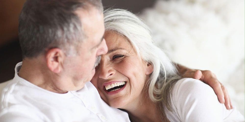 Senior couple cuddling and laughing.