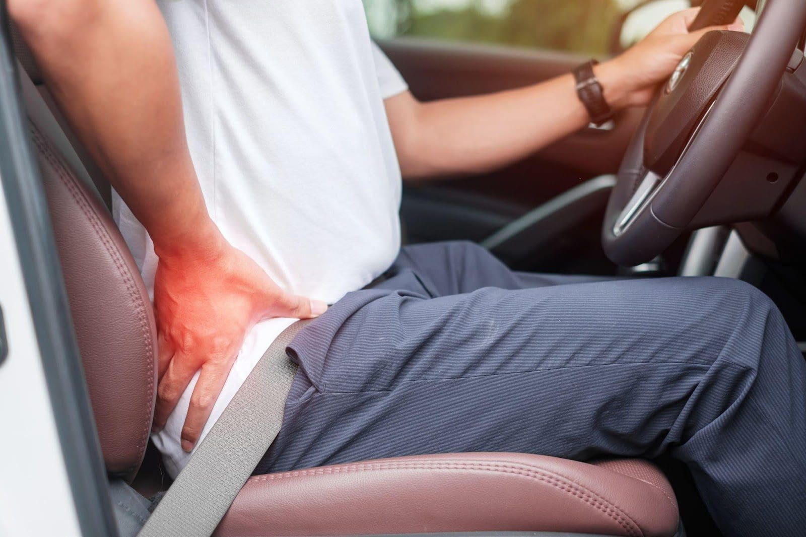 Man driving a car, experiencing Piriformis pain.
