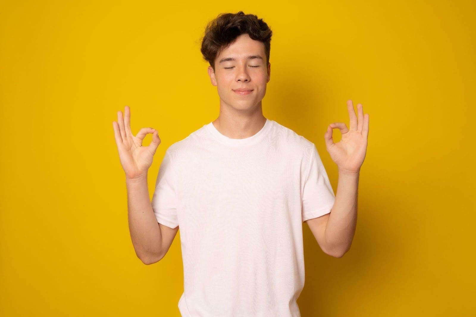 Young man in relaxed posture, smiling with his eyes closed.