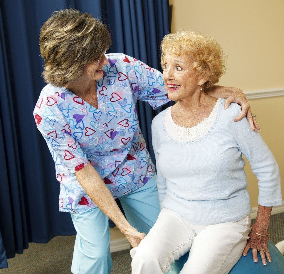 A chiropractor treats an elderly woman.