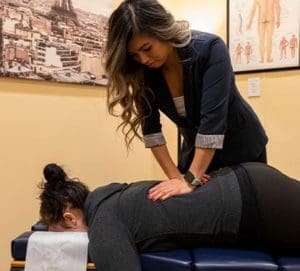 A chiropractor is treating a woman's back for an auto injury.