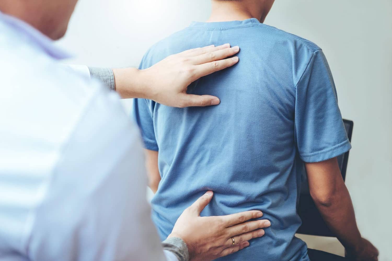 A man is being treated by a chiropractor for back pain.