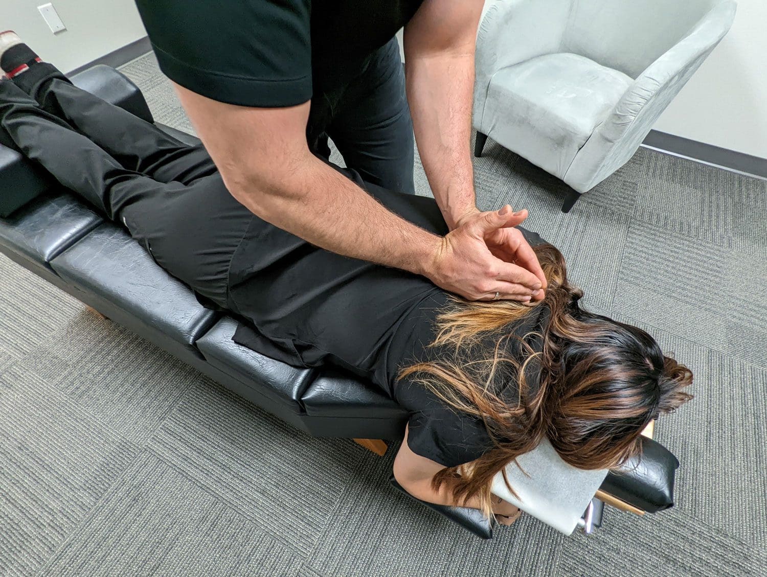 A chiropractor administering an adjustment on a patient.