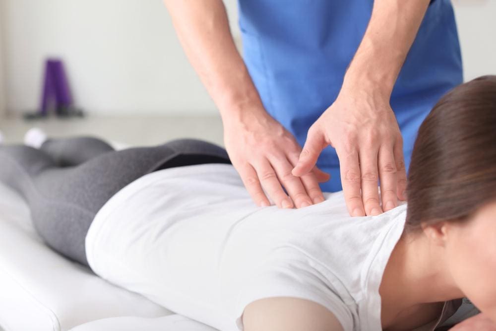 A chiropractor is treating a woman for nerve damage. 