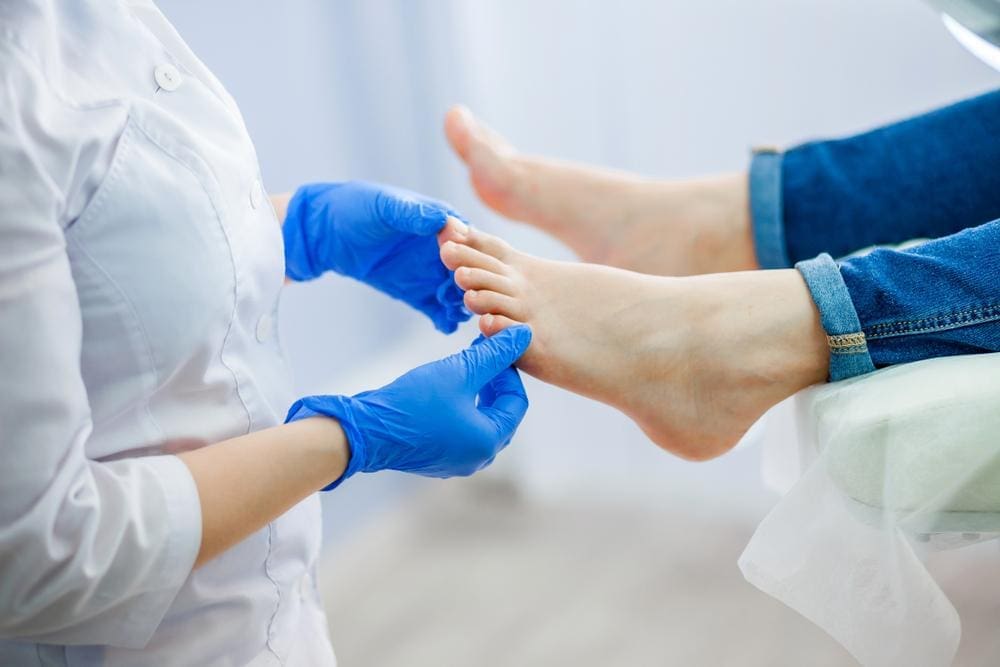A chiropractor is examining a patient's foot to assess plantar fasciitis treatment. 