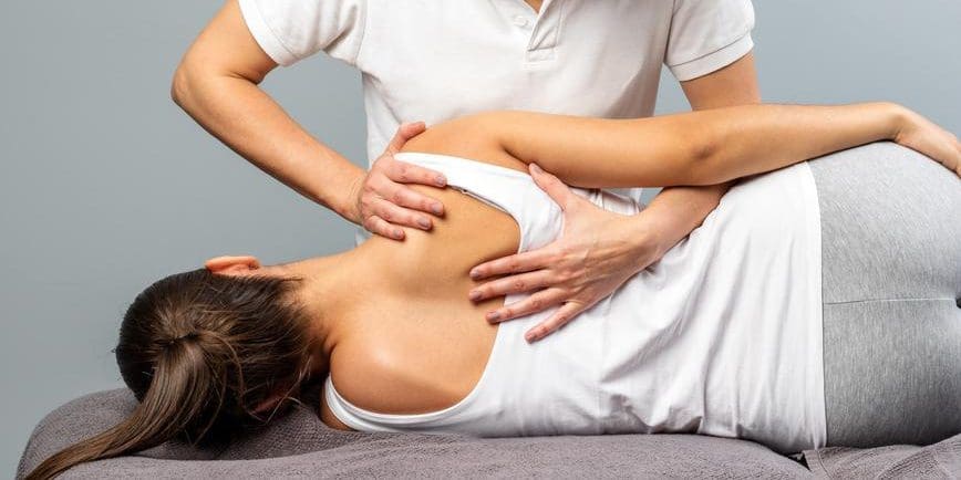 A woman is getting treated by an osteopathic doctor.