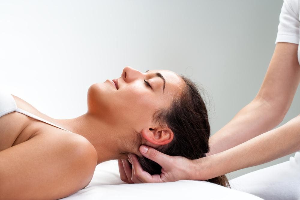 A woman is getting an upper cervical chiropractic adjustment to ease Trigeminal Neuralgia pain. 
