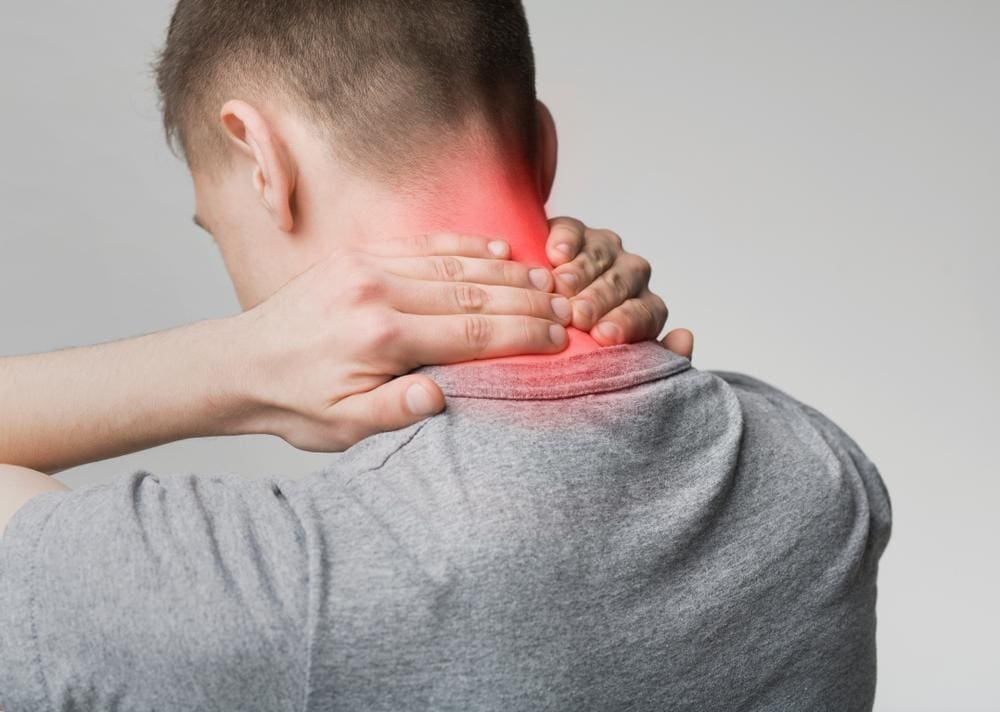 A man is holding the back of his neck because he is suffering from cervical arthritis pain. 