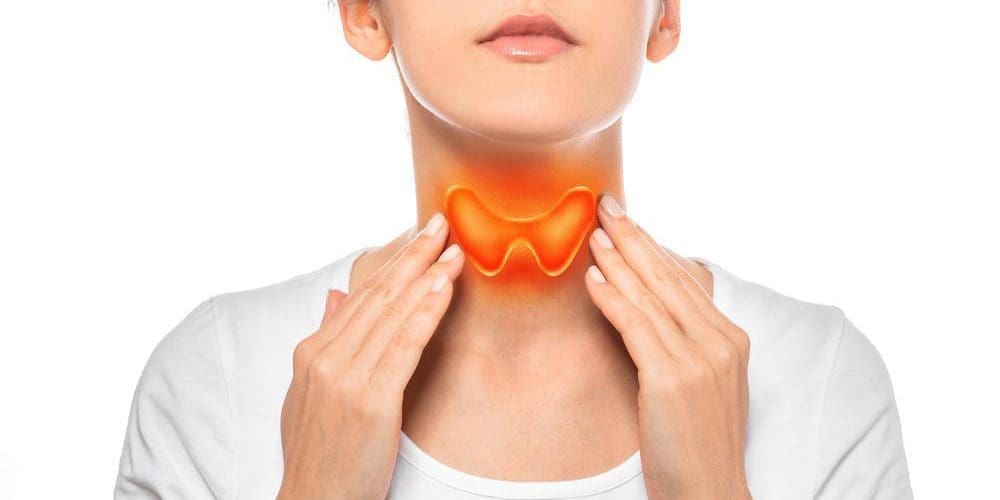 Woman showing a painted thyroid gland on her neck.