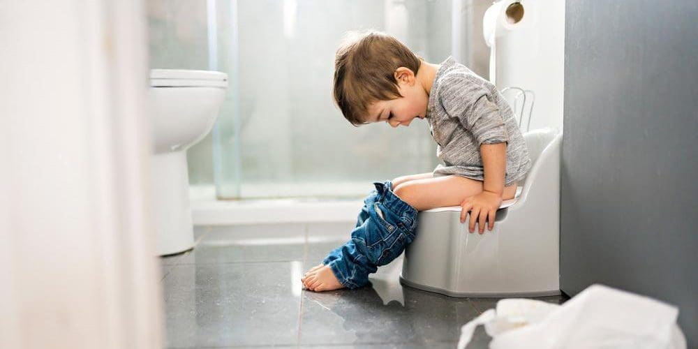 Little boy with Encopresis sitting on a child toilet.