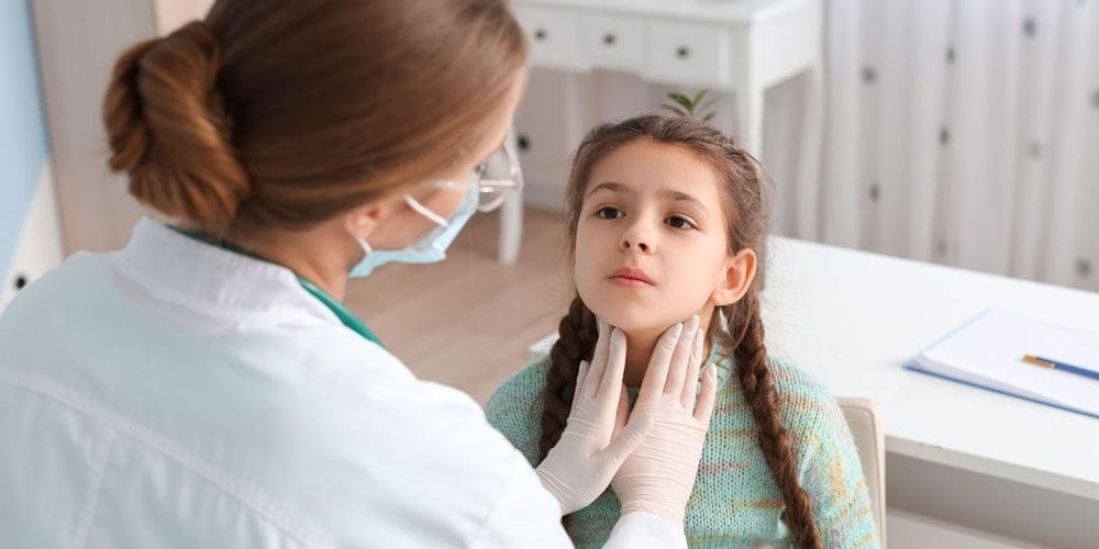 A doctor examines a young girl's tonsils.