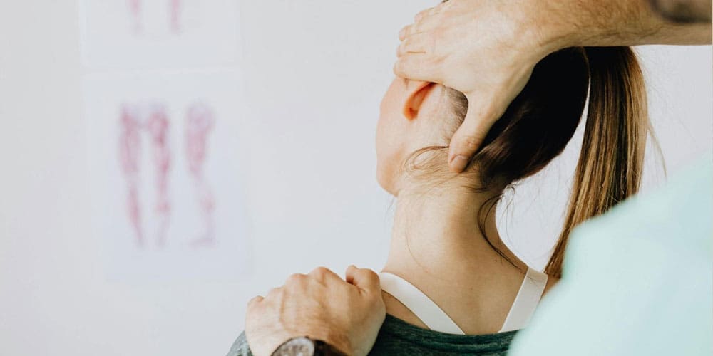 Woman having neck adjusted by chiropractor